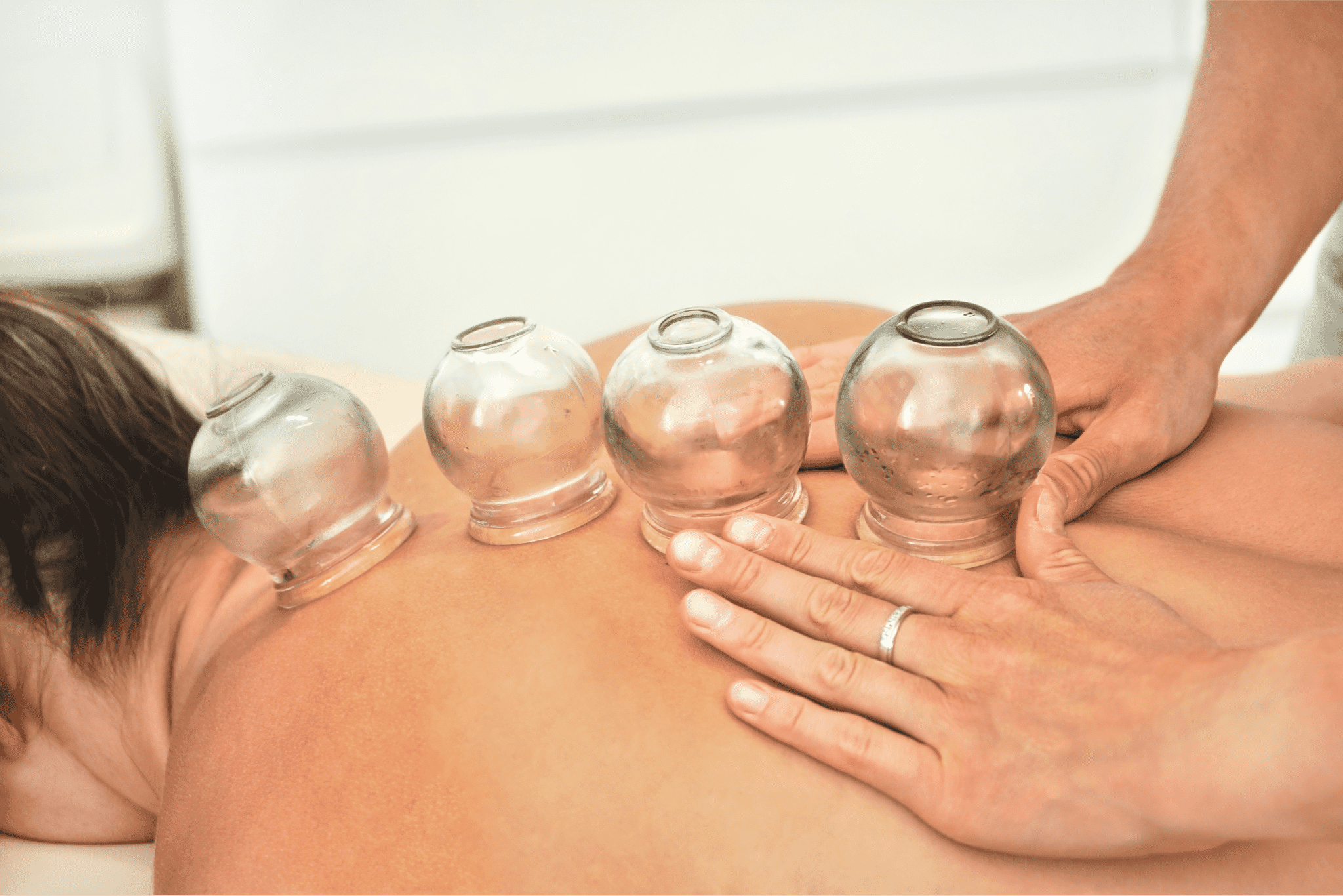 young-female-physiotherapist-applying-glass-suction-banks-back-her-patient-during-cupping-therapy-closeup-detail